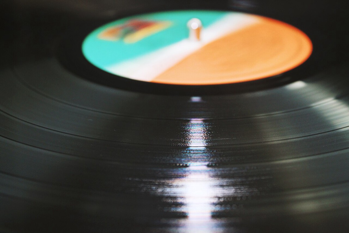 Close-up of a vinyl record with light reflecting off the grooves